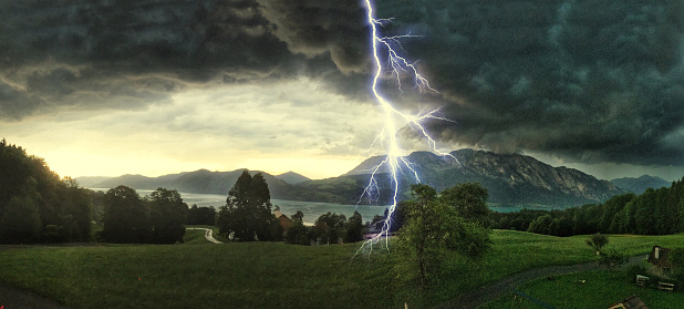 Thunderstorm with lightning strikes over the Alps at Lake Attersee, Salzburg Austria, Concept for insurance damage, security, severe weather and climate change