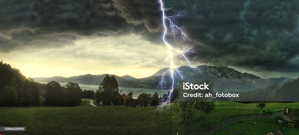 Thunderstorm with lightning strikes over the Alps at Lake Attersee, Salzburg Austria, Concept for insurance damage, security, severe weather and climate change Lightning Stock Photo