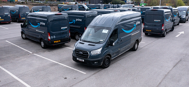 Leeds, UK - April 25, 2022.  A fleet of Amazon Prime Ford Transit delivery vans ready to be loaded to deliver online shopping items to homes in the UK