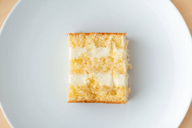 cake cut with sponge biscuit and cream cheese layers on the white background. Copy space. Flat lay