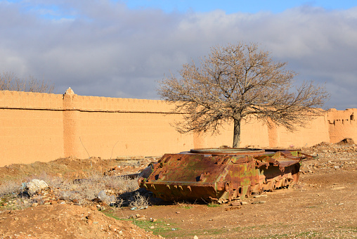 Kholm / Khulm / Tashqurghan, Balkh province, Afghanistan: rusting hull of Soviet T-55 main battle tank by the Bagh-e Jahan Nama Palace perimeter wall - designed in the Ukrainian SSR by the Kharkiv Morozov Machine Building Design Bureau (KMDB).