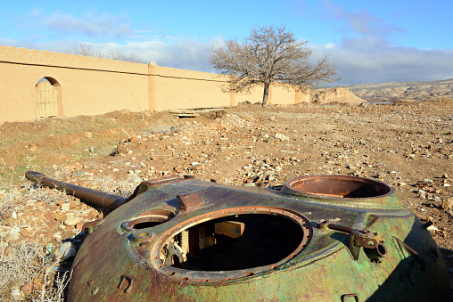 Kholm / Khulm / Tashqurghan, Balkh province, Afghanistan: severed turret of a Soviet T-55 tank by the Bagh-e Jahan Nama Palace perimeter wall - war remains.