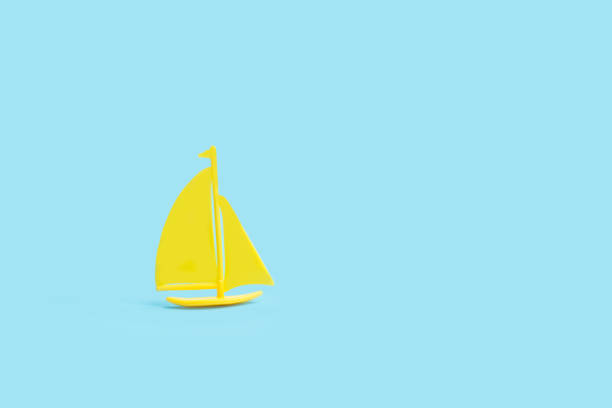 istock Yellow toy boat on a light blue background 1394031968