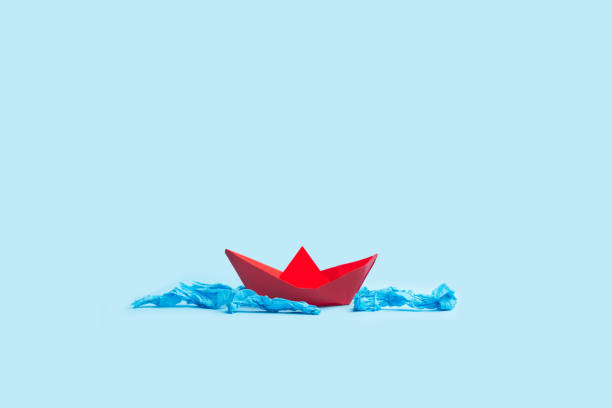 istock Red paper toy boat on a light blue background 1394031991