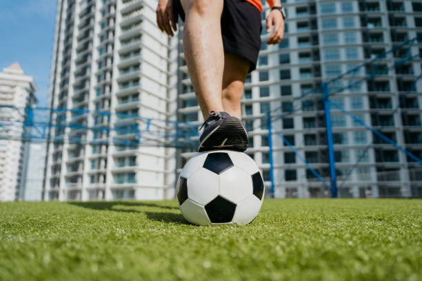 Feet of an Asian soccer player on soccer ball Low angle close up shot of feet of an Asian soccer player on soccer ball at soccer field men close up 20s asian ethnicity stock pictures, royalty-free photos & images