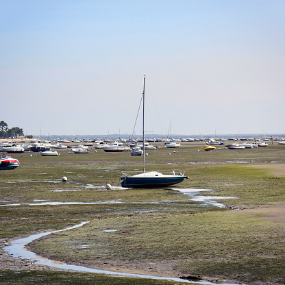 Small sailboat stranded at low tide in Andernos-les-bains.