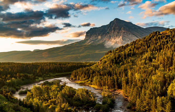 dramático amanecer de verano en el lago swift current en el área de many glacier en el parque nacional glacier con el grinnell mt iluminado por el amanecer. - montana us glacier national park usa glacier fotografías e imágenes de stock