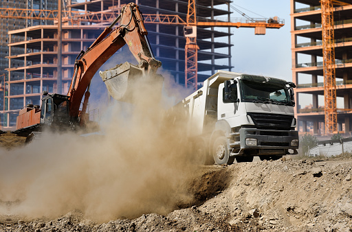 Excavator and truck working in construction site