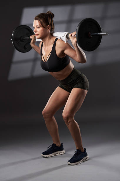 istock Woman doing barbell squats 1394041555