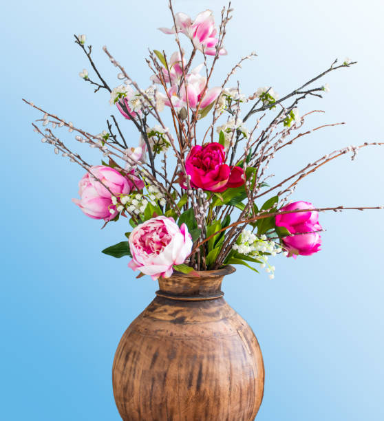 Wildflower bouquet with peonies against a blue background.