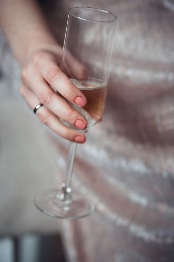 a glass of champagne in the hand of a woman close up