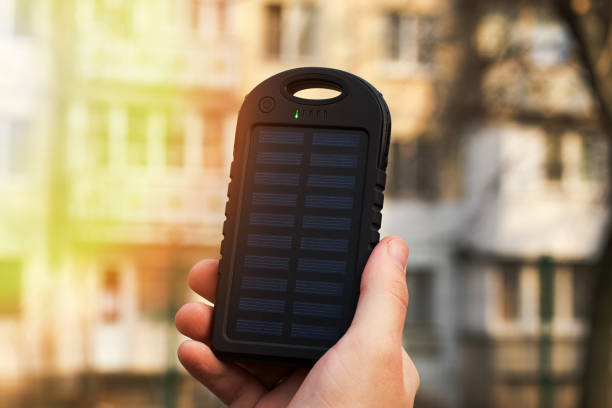 fotografia de close-up da mão do homem, segurando powerbank com bateria solar. - elecronic - fotografias e filmes do acervo