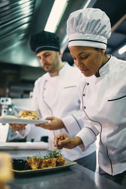 istock African American professional cook serving a dish in a restaurant. 1394053828