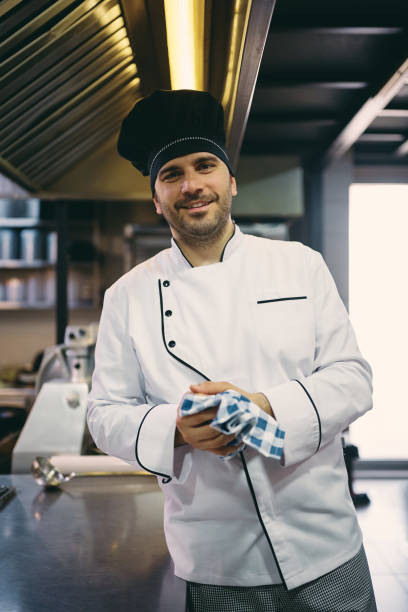 istock Professional male cook working in a restaurant and looking at camera. 1394053829