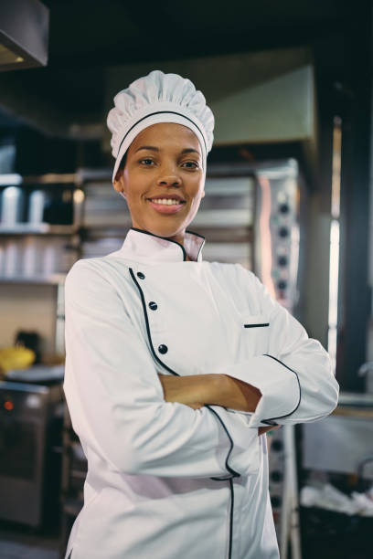 istock Professional black chef standing with her arms crossed and looking at camera. 1394053881