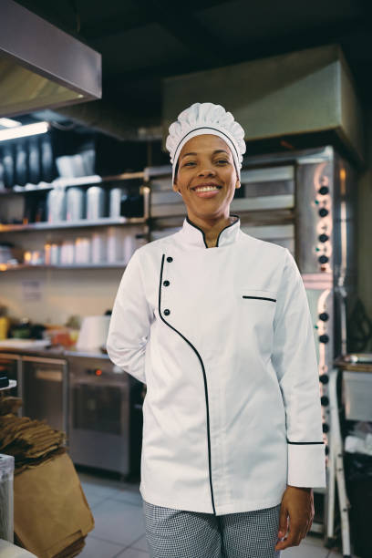 istock Happy professional female cook in a restaurant looking at camera. 1394053951