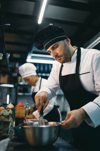 istock Male chef preparing meal while cooking in the kitchen at restaurant. 1394054908