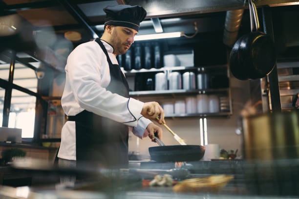 istock Professional cook preparing meal while working in the kitchen at restaurant. 1394055119