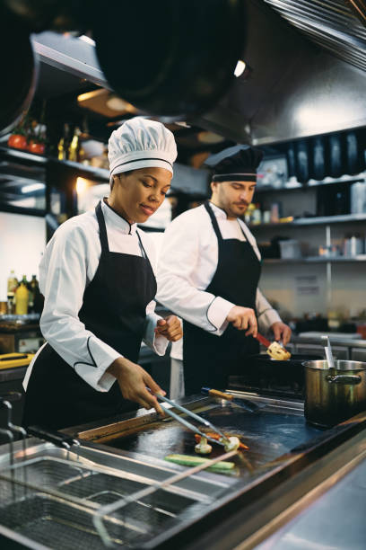 istock Two restaurant chefs preparing food in the kitchen. 1394055229