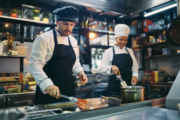istock Two professional cooks working in the kitchen at restaurant. 1394055299