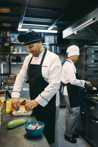 istock Happy male chef preparing meal while working in a restaurant. 1394055438