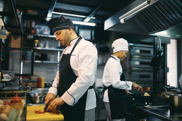 istock Two professional chefs preparing meal at restaurant kitchen. 1394055496