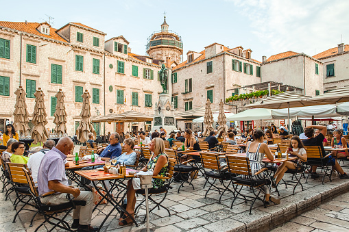 Dubrovnik, Croatia - September 18, 2019: Open Air Restaurant terrace in the Old Town of Dubrownik with lots of tourists enjoy their vacations in Croatia