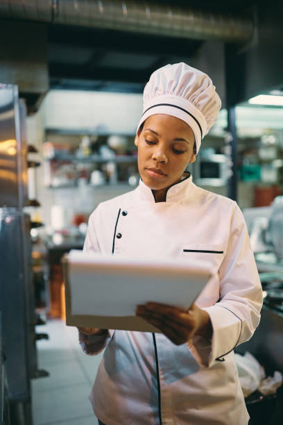 istock African American female chef taking notes while working in a restaurant. 1394056647
