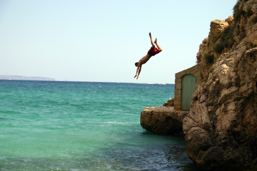 A kid jumping off a cliff