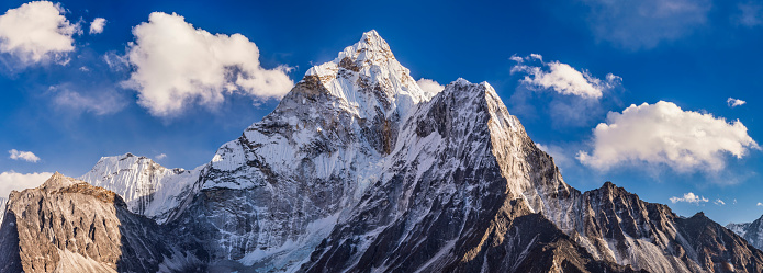 44 MPix XXXXL size panorama of Mount Ama Dablam - probably the most beautiful peak in Himalayas. 
 This panoramic landscape is an very high resolution multi-frame composite and is suitable for large scale printing
Ama Dablam is a mountain in the Himalaya range of eastern Nepal. The main peak is 6,812  metres, the lower western peak is 5,563 metres. Ama Dablam means  'Mother's neclace'; the long ridges on each side like the arms of a mother (ama) protecting  her child, and the hanging glacier thought of as the dablam, the traditional double-pendant  containing pictures of the gods, worn by Sherpa women. For several days, Ama Dablam dominates  the eastern sky for anyone trekking to Mount Everest basecamp