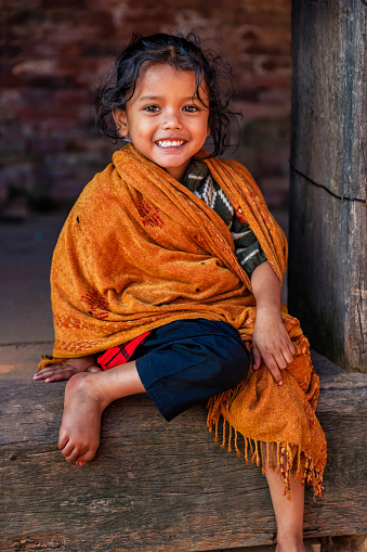 Portrait of happy little Nepali girl, she lives in Bhaktapur. Bhaktapur is an ancient town in the Kathmandu Valley and is listed as a World Heritage Site by UNESCO for its rich culture, temples, and wood, metal and stone artwork.