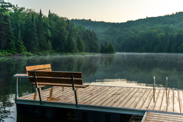 Young woman reading a book while sitting by the lake.