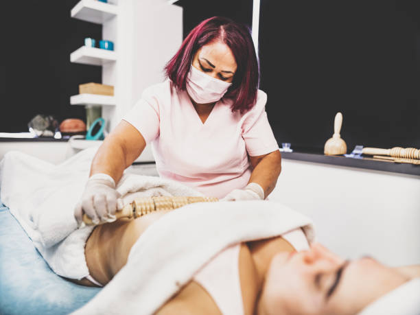istock Female massage therapist treating customer with abdomen massage 1394067576