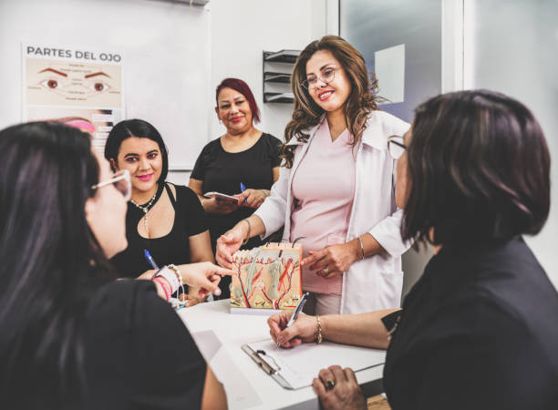 Female Beautician instructor teaching women at the class stock photo