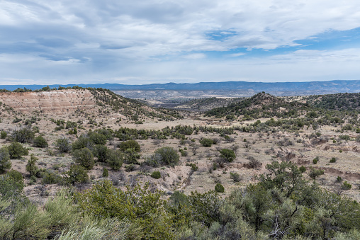 Landslides occur when a slope, or a portion of it, undergoes some processes that make it unstable. This decreases the shear strength of the slope material, causing gravity to carry the material downhill.  A landslide may be caused by excess water, earthquakes, or any combination of other factors acting together or alone.  The landslide in the far left of the picture and the resulting chasm were photographed from the Copper Canyon Trail in the Prescott National Forest near Camp Verde, Arizona, USA.