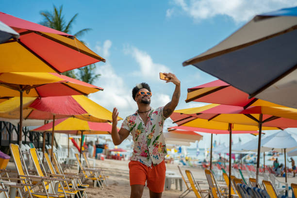 vlogging dell'uomo sulla spiaggia - tropical culture foto e immagini stock