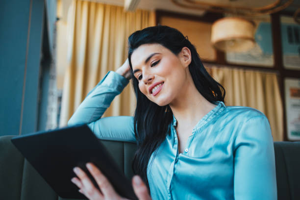 istock Beautiful Woman Using a Tablet in a Coffee Shop 1394074421