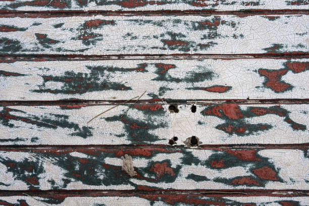 Abstract background of paint peeling on red wall.