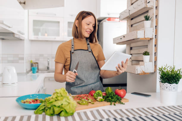 istock Young woman making a vegetable meal at her kitchen 1394091576