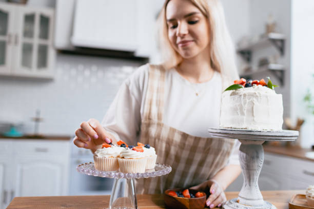 istock Pastry chef confectioner young caucasian woman with cake on kitchen table. 1394092272