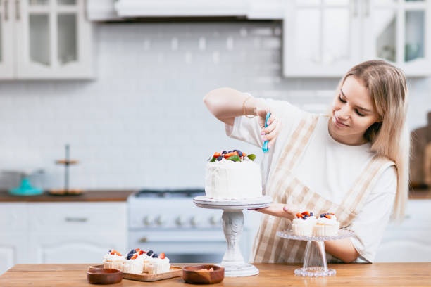 istock Pastry chef confectioner young caucasian woman with cake on kitchen table. 1394092279