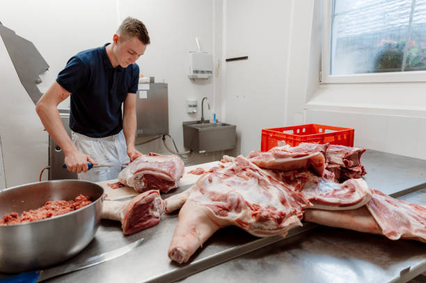 istock Young butcher cutting meat 1394092366