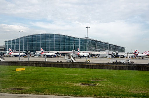 London, UK - April 19, 2022: Stands full of British Airways planes at the main Terminal 5 building at London's Heathrow Airport on a sunny spring morning.