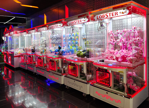 Kuala Lumpur,Malaysia - April 25,2022 : Colorful arcade game toy claw crane machine where people can win toys and other prizes which is located in the shopping mall,Kuala Lumpur.