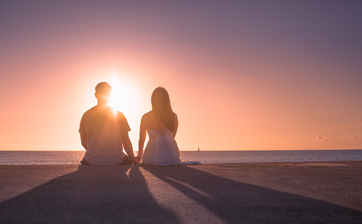 Romantic couple enjoying beautiful sunset in Hawaii.