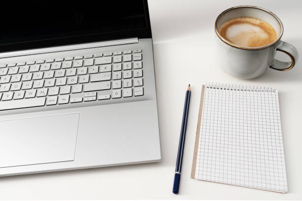istock laptop computer and note pad on white office desk with cup of coffee 1394100300