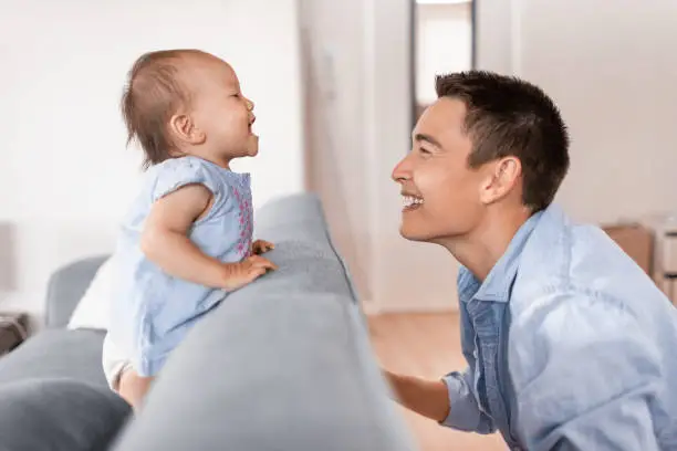 Cute portrait of father and his baby girl playing