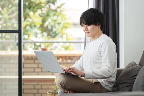 istock Asian man using a computer in his living room 1394107404
