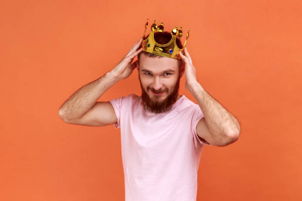 istock Man wearing golden crown, looking with positive facial expression, privileged status. 1394110704