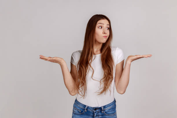 istock Funny confused girl shrugging shoulders with clueless embarrassed expression, having doubts. 1394110856
